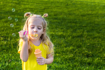 girl lets the soap bubbles in the street. concept happy childhood