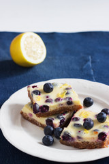 Lemon bars shortbread crumbly crust blue jeans background.