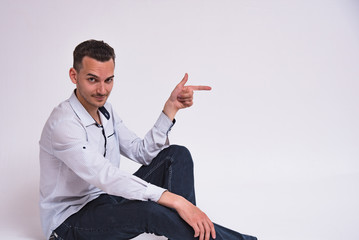 portrait of a cute young man sitting on the floor on a white background