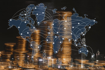 Double exposure of coin stack with city background and world map, financial graph, world map and global network business concept.