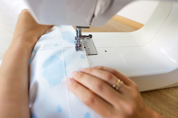 Obraz na płótnie Canvas Image of seamstress working on sewing machine