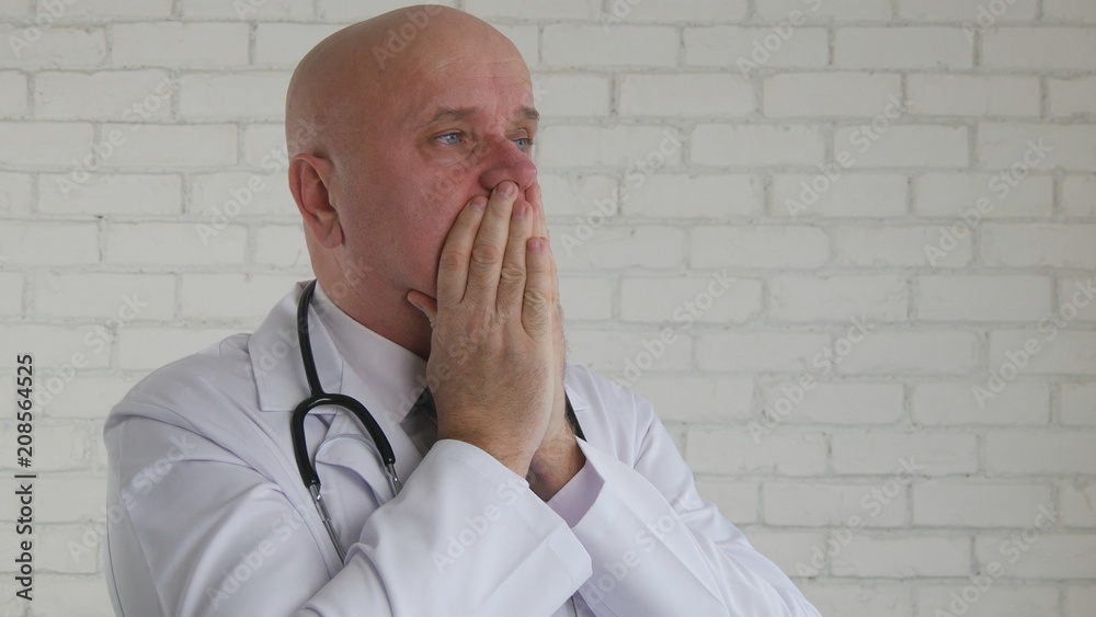 Wall mural upset and disappointed doctor cover his face with hands in a desperate gestures