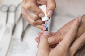 Applying coat of nail varnish in beauty salon