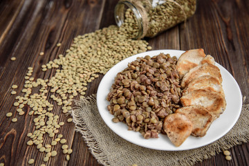 Grilled chicken with lentils on white plate. Healthy dinner