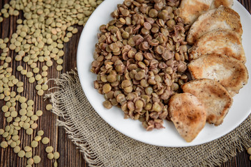 Grilled chicken with lentils on white plate. Healthy dinner