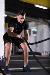 Plakat athlete man doing battle ropes cross fitness exercise
