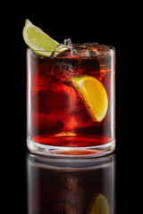 Rum and cola cocktail in Rocks glass isolated on black