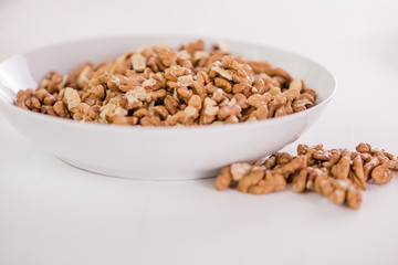 bowl of whole wallnuts on white background