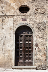 Fototapeta na wymiar Beautiful old wooden door in San Gimignano