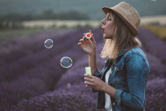 Beautiful Woman Blowing Soap Bubble