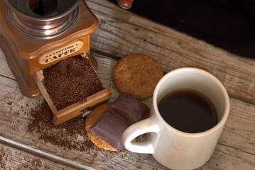 close-up of coffee mug with biscuits and chocolate on wooden boards 