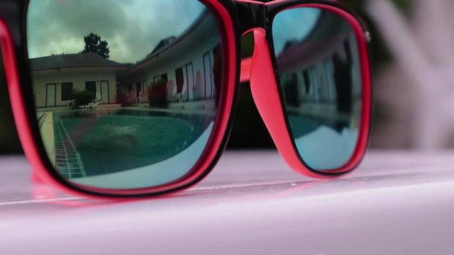 reflection in sunglasses of teenagers girl enjoy in hotel swiming pool in vacation. two sisters playing, swimming and jumping in water