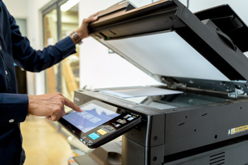 Bussiness man Hand press button on panel of printer, printer scanner laser office copy machine supplies start concept.