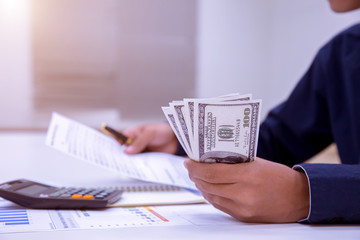 Asian male accountants or bankers perform calculations. Financial savings and economic ideas for 2018 through laptops in the office.