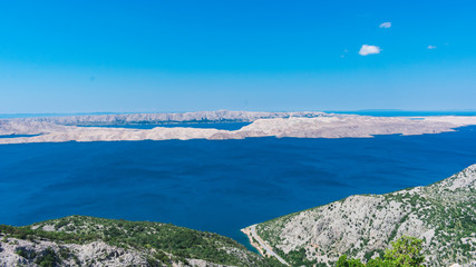 Seascape view of white stony islands in the clear blue Adriatic sea on a sunny day from above. Summer in Croatia or travel concept