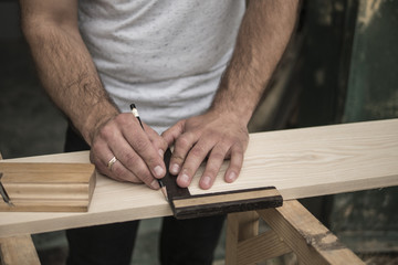 The joiner marks the workpiece with a pencil. joinery