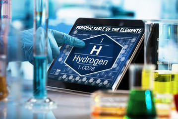 scientist consulting on the digital tablet data of the chemical element Hydrogen H / researcher...
