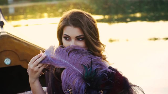 Beautiful brunette posing over beautiful romantic landscape. Traditional Venetian rowing boat