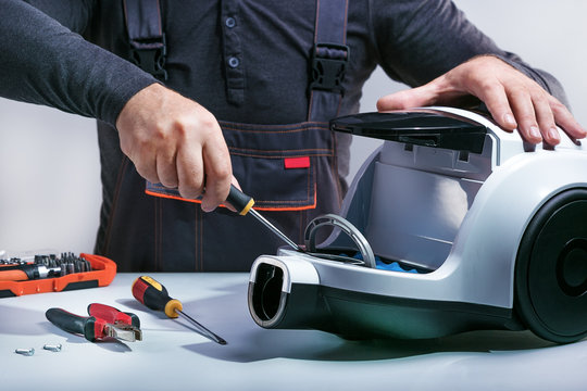 Repairman repairs of vacuum cleaner. Repairing cleaner.Small business.