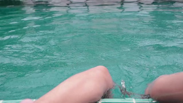 Cute teenager girl playing laughing swimming in hotels pool having fun
