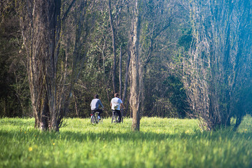two friends cycling at the park. Outdoor Healthy Lifestyle (at the bottom of the image there is a defocused zone ideal for inserting text)