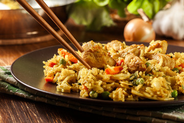 Fried rice nasi goreng with chicken and vegetables on a plate