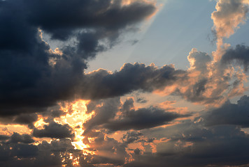 Fototapeta na wymiar The rays of sunset through dark clouds are majestic, dramatic.