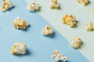 The popcorn in paper cup on green and blue background.
