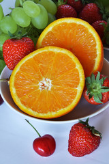 Fototapeta na wymiar frutta fresca pronta da mangiare, arancia, fragola, ciliegia, uva