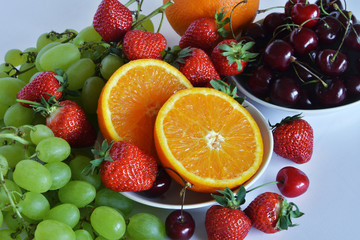 Fototapeta na wymiar frutta fresca pronta da mangiare, arancia, fragola, ciliegia, uva