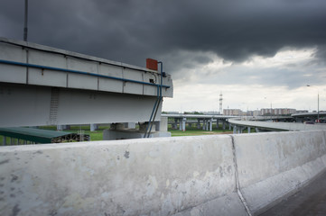 Urban Elevated Roads with concrete blocks on both sides. Black clouds on the sky. Storm is coming