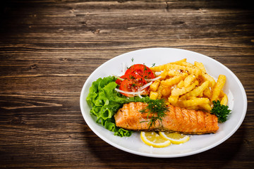 Fried salmon, chips and vegetables
