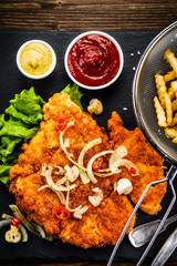 Fried pork chop, French fries and vegetable salad