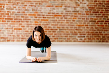  Charming young woman doing push up exercise  in modern loft interior.