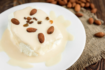 Cottage cheese with yogurt and almonds on dark wooden background. Healthy food.