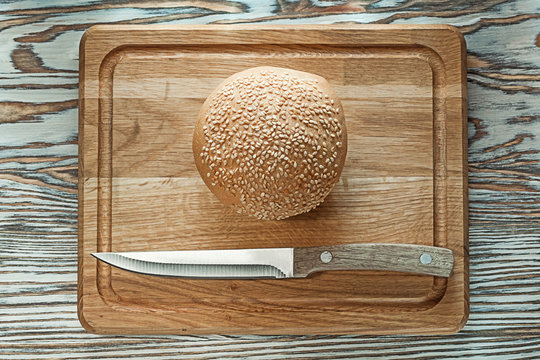 Chopping board knife bread on wooden surface