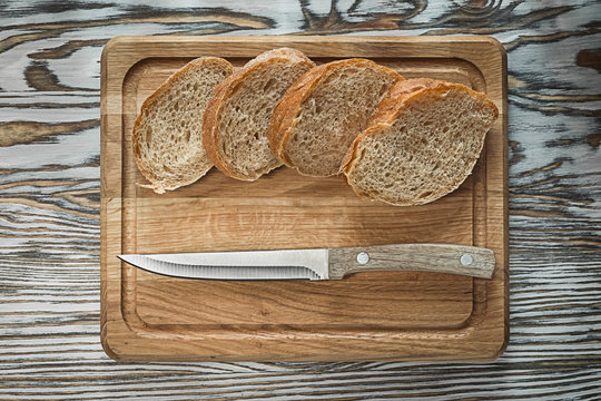 Chopping board knife sliced bread on wooden surface