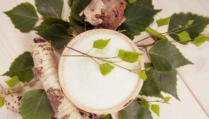 Xylitol - sugar substitute. Birch sugar on white wooden background.