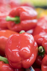 close up of red peppers on market stand. Ripe red bell peppers on the shelf in grocery store.