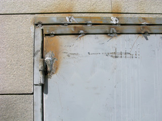 Arc welding on the old metal door. Weld seams on metal door frame and door hinge. Close-up.