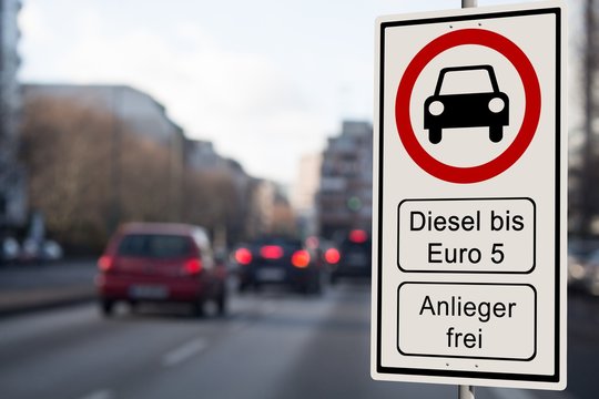 Diesel Fahrverbot Schild - Verbotsschild Diesel Fahrverbot bis Euro 5 - Anlieger frei - Straßenverkehr im Hintergrund