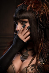 Portrait of brunette woman with dark gothic makeup and creative hairstyle