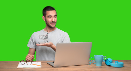 Concept of a happy young man who buy on internet  - Green background