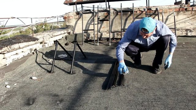 man paints a metal rack with spray paint