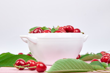 Red cherry in white bowl