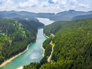 Beautiful turquoise waters of the mountain lake. Vibrant Blue  Lake in the mountain forest.  Top view of the taiga forest and river. Big lake in Siberia. Russia