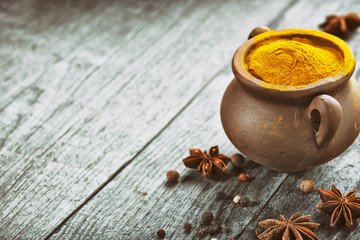 Turmeric powder on wooden background.