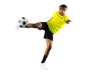 Tuinposter Soccer player man with dark skinned playing kicking the ball © luismolinero