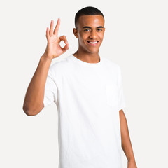 Young african american man showing an ok sign with fingers. Face of happiness and satisfaction on isolated background