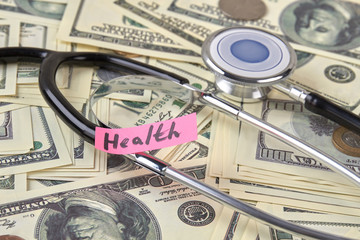 Dollars and stethoscope, close up. Expensive health care concept.